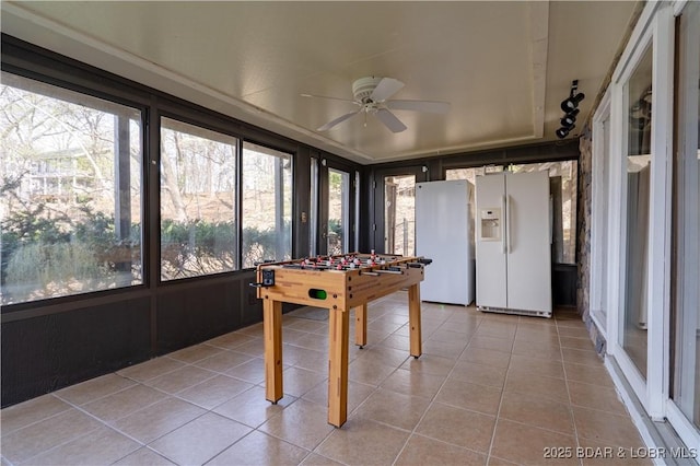 sunroom with a ceiling fan and tile patterned flooring
