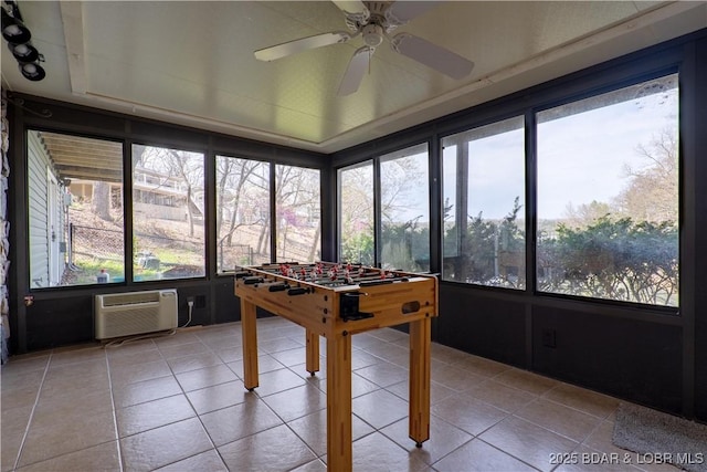 rec room with light tile patterned floors, ceiling fan, and an AC wall unit