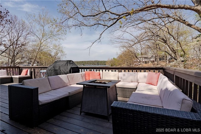 deck with an outdoor living space with a fire pit
