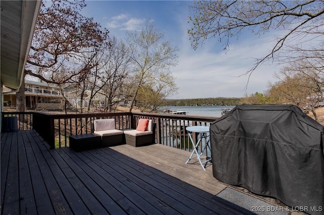 wooden deck featuring central AC unit, a water view, and area for grilling