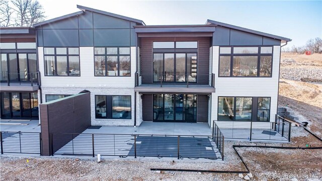 back of property featuring a patio area and a balcony