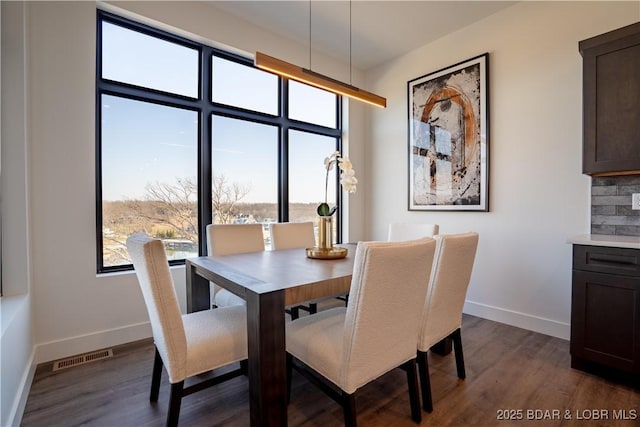 dining space with baseboards, dark wood-style floors, and visible vents