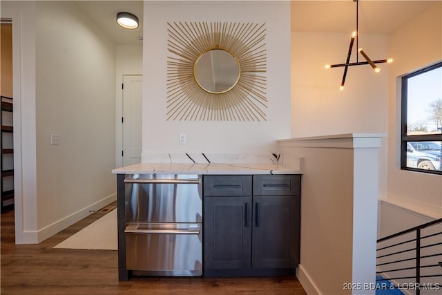 kitchen featuring baseboards, dark wood-style flooring, and a notable chandelier