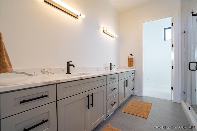 bathroom featuring double vanity, baseboards, and a sink