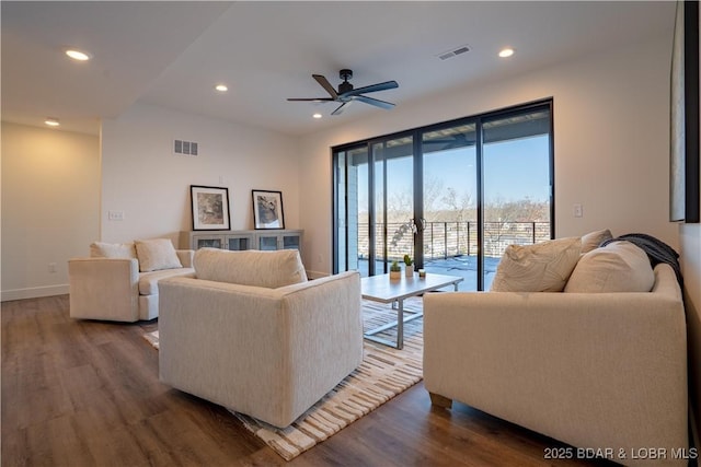 living area featuring ceiling fan, visible vents, and dark wood-style floors