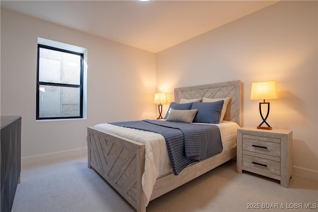 bedroom with light colored carpet and baseboards