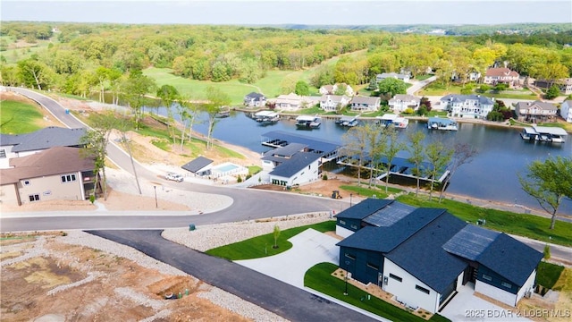 drone / aerial view featuring a residential view, a water view, and a wooded view