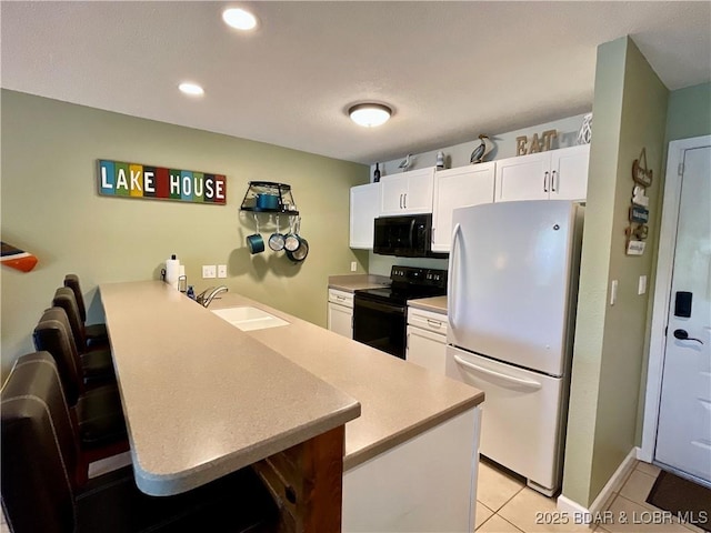 405 Barba Le Ln Unit 3B, Lake Ozark, MO 65049 - kitchen featuring a sink, light countertops, black appliances, a peninsula, and white cabinetry