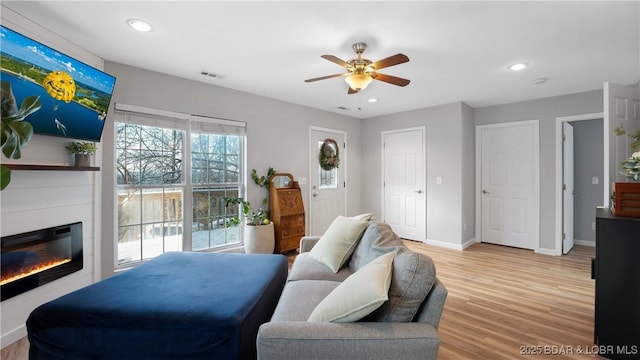 298 Storm Cove Dr, Linn Creek, MO 65052 - living area featuring light wood-style floors, a ceiling fan, visible vents, a glass covered fireplace, and recessed lighting
