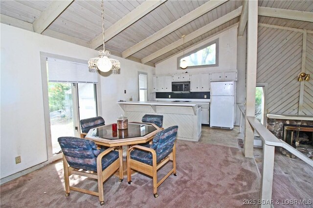 1483 Bluff Dr, Osage Beach, MO 65065 - dining room featuring high vaulted ceiling, a notable chandelier, light carpet, and plenty of natural light