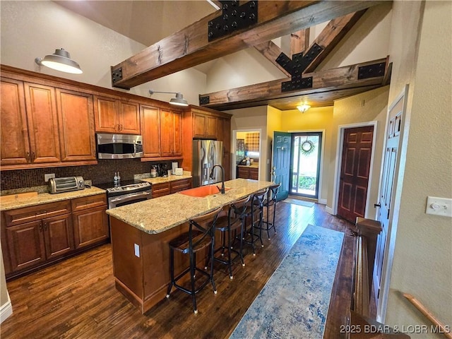 212 Weiskopf Way, Camdenton, MO 65020 - kitchen with appliances with stainless steel finishes, high vaulted ceiling, backsplash, a center island with sink, and dark wood-style floors