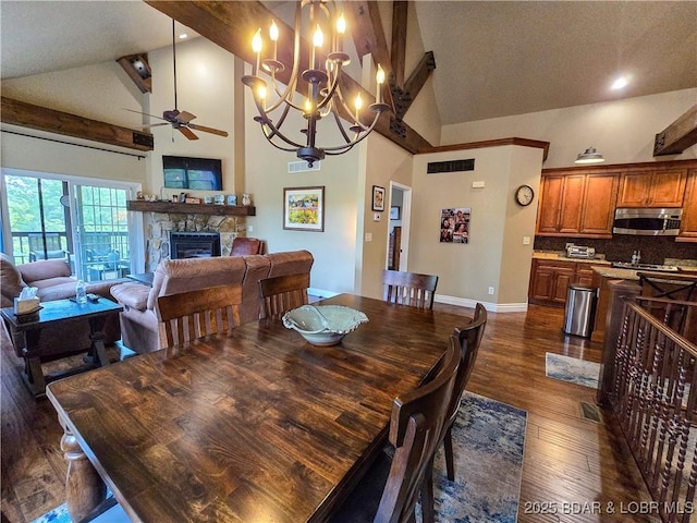 dining room with a fireplace, baseboards, dark wood-style floors, high vaulted ceiling, and ceiling fan with notable chandelier