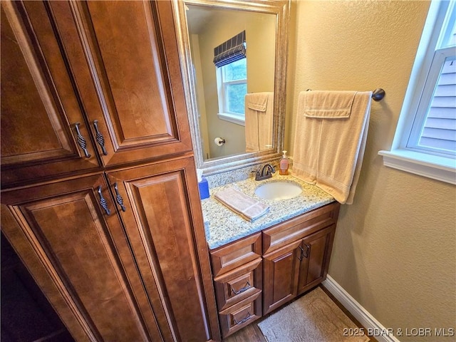 bathroom featuring vanity and a textured wall