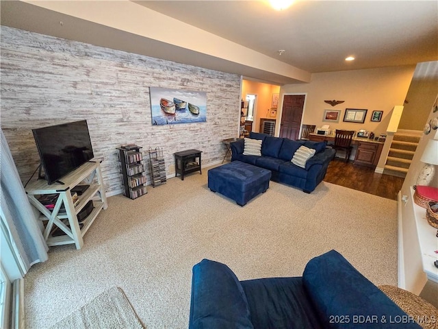 carpeted living area featuring recessed lighting, a wood stove, and stairs