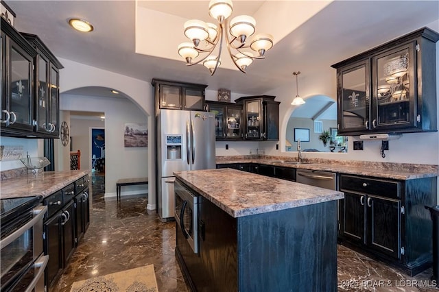 106 Bayliner Dr, Sunrise Beach, MO 65079 - kitchen featuring arched walkways, marble finish floor, stainless steel appliances, and a kitchen island