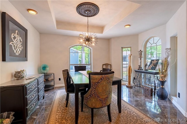 106 Bayliner Dr, Sunrise Beach, MO 65079 - dining area featuring baseboards, marble finish floor, a tray ceiling, and a chandelier