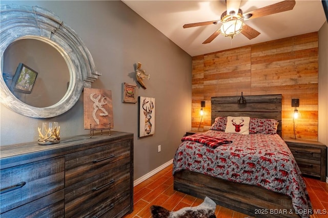 106 Bayliner Dr, Sunrise Beach, MO 65079 - bedroom featuring an accent wall, ceiling fan, wooden walls, and baseboards