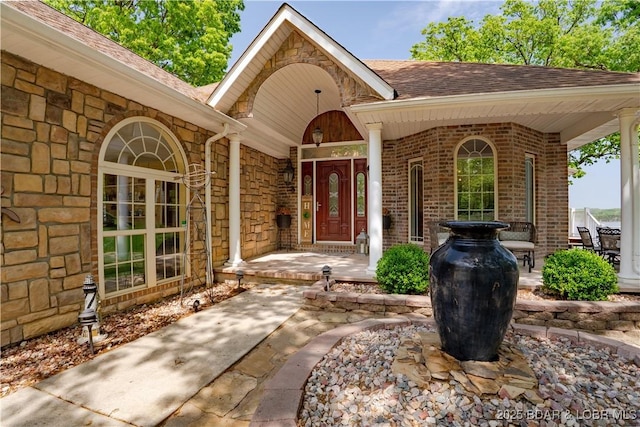 106 Bayliner Dr, Sunrise Beach, MO 65079 - entrance to property with covered porch, roof with shingles, brick siding, and stone siding