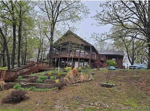 rear view of house featuring stairway and a deck