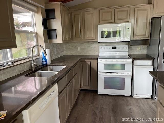 kitchen with dark wood-style flooring, tasteful backsplash, a sink, dark stone counters, and white appliances