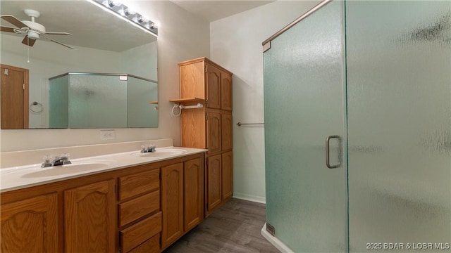 168 Shady Oaks Cir, Sunrise Beach, MO 65079 - bathroom featuring a ceiling fan, wood finished floors, a sink, and a stall shower