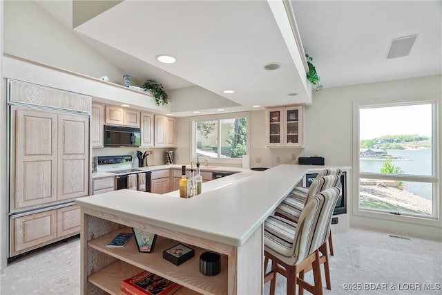 kitchen with open shelves, black microwave, a breakfast bar, electric stove, and paneled fridge
