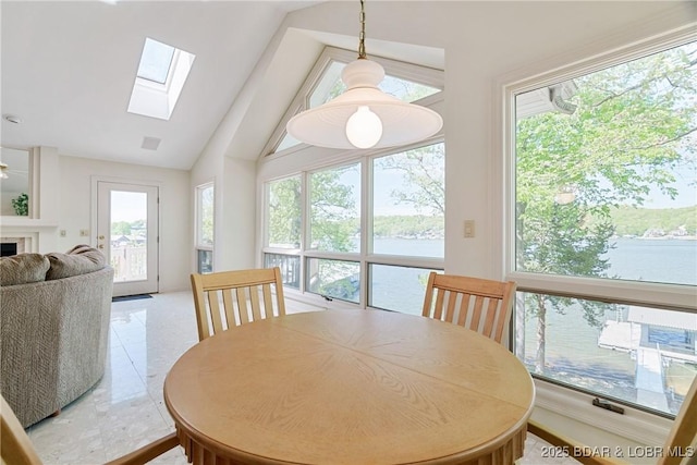 dining area featuring vaulted ceiling with skylight and a wealth of natural light