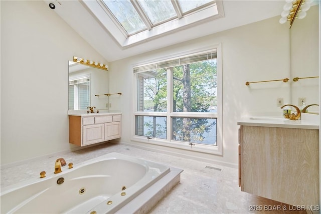 bathroom with visible vents, a jetted tub, lofted ceiling with skylight, and vanity