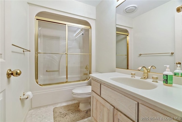 bathroom with toilet, combined bath / shower with glass door, and vanity