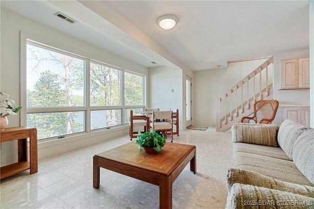living room with stairs, visible vents, and plenty of natural light