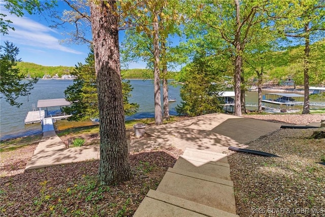 view of yard with a water view and a floating dock