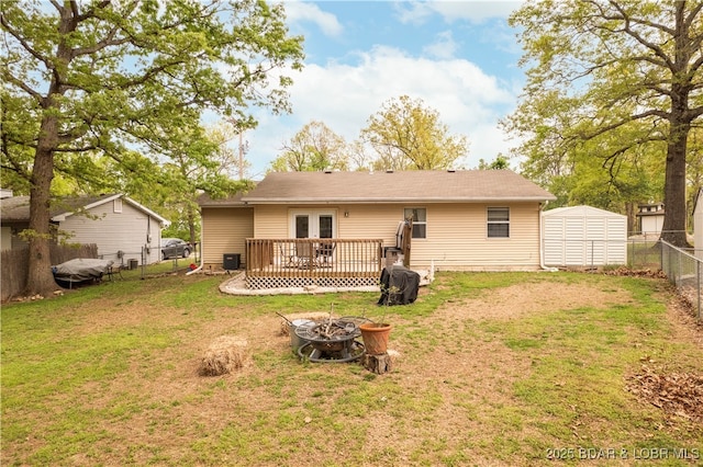 1497 Cherokee Rd W, Lake Ozark, MO 65049 - rear view of property with a fire pit, a deck, a fenced backyard, french doors, and a yard