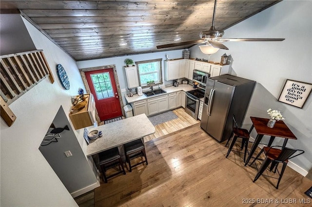kitchen featuring a sink, wooden ceiling, a ceiling fan, and stainless steel appliances