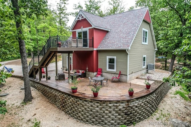 back of property featuring stairway, an outdoor living space, a wooden deck, and a patio area