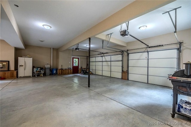 garage featuring a garage door opener and white refrigerator with ice dispenser