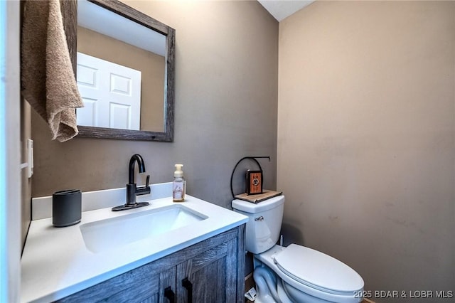 half bathroom with vanity and toilet