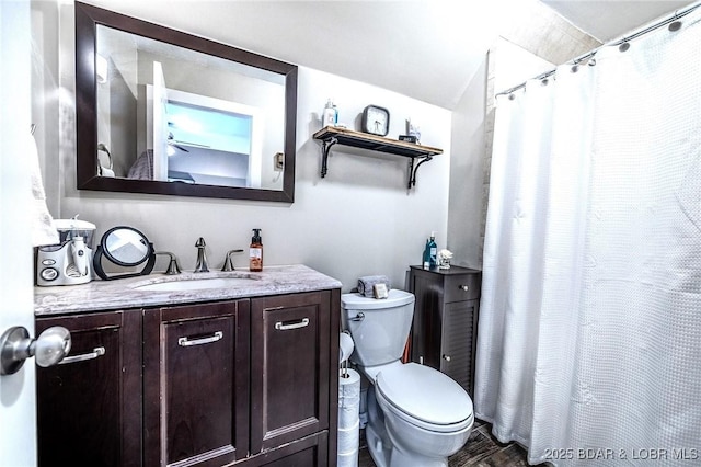 full bath with vanity, curtained shower, wood finished floors, toilet, and vaulted ceiling