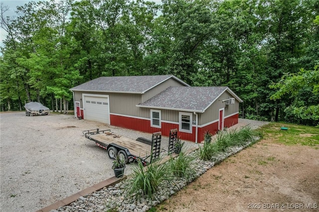 view of home's exterior featuring roof with shingles and a detached garage