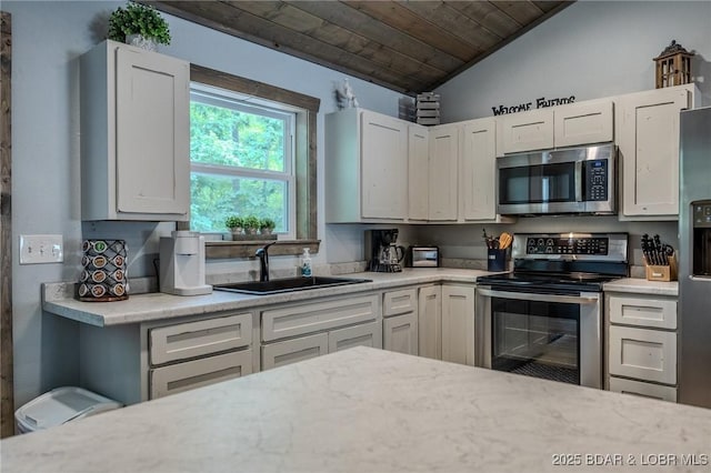 kitchen with lofted ceiling, white cabinets, wooden ceiling, a sink, and appliances with stainless steel finishes