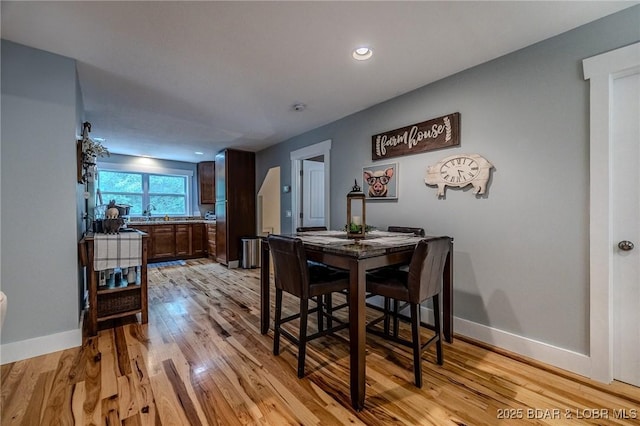 dining room with baseboards, recessed lighting, and light wood finished floors