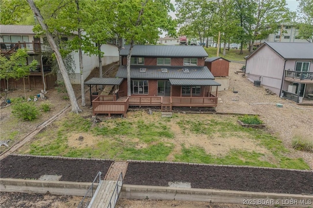 rear view of house featuring a deck and metal roof