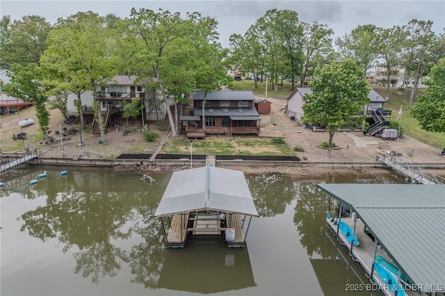 dock area featuring boat lift and a deck with water view