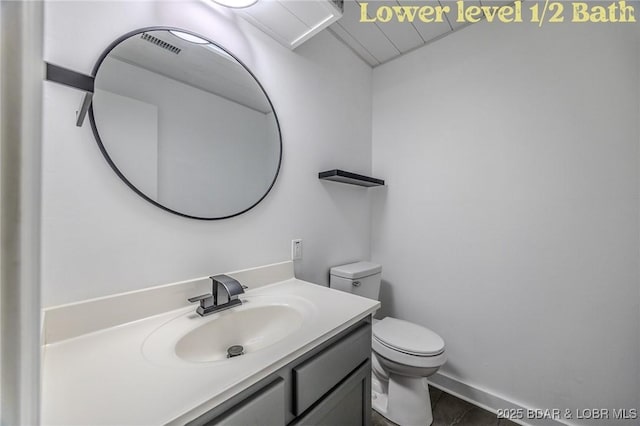 bathroom with vanity, visible vents, and toilet