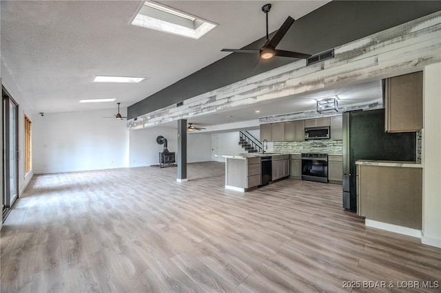 below grade area featuring baseboards, a ceiling fan, light wood-type flooring, and visible vents