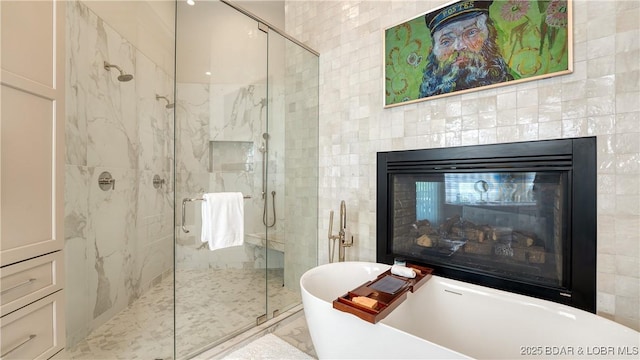 559 Forestridge Ln, Sunrise Beach, MO 65079 - full bath with a marble finish shower, a soaking tub, a glass covered fireplace, and tile walls