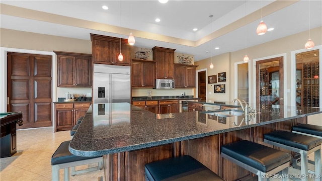 559 Forestridge Ln, Sunrise Beach, MO 65079 - kitchen with appliances with stainless steel finishes, a sink, a spacious island, a kitchen bar, and recessed lighting