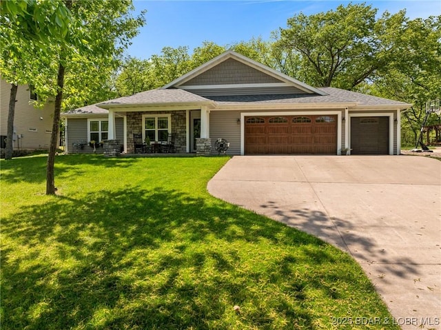 view of front of house with a porch, driveway, a front yard, an attached garage, and stone siding
