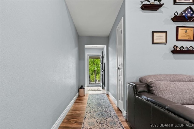 hall featuring baseboards and wood finished floors