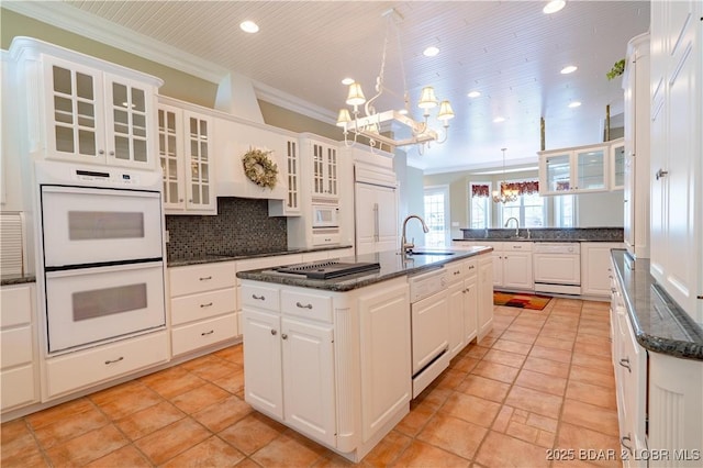 188 Bur Oaks Rd, Camdenton, MO 65020 - kitchen featuring white appliances, a chandelier, ornamental molding, decorative backsplash, and a kitchen island with sink