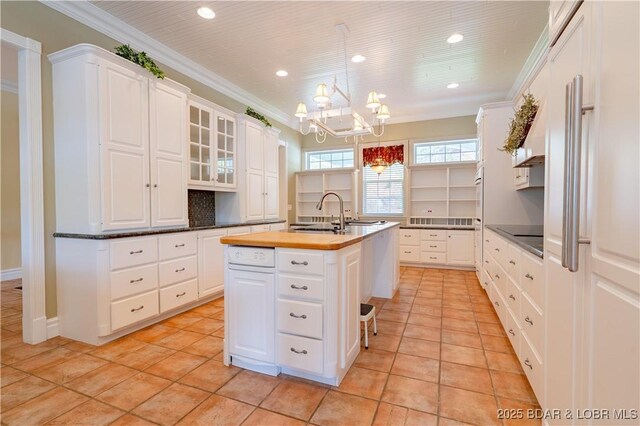 188 Bur Oaks Rd, Camdenton, MO 65020 - kitchen with a kitchen island with sink, light tile patterned floors, recessed lighting, white cabinetry, and ornamental molding